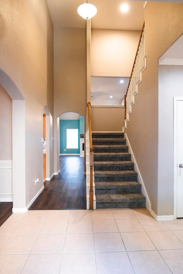 30615 S Sulphur Creek Dr, Magnolia, TX 77355 - staircase featuring baseboards, arched walkways, a high ceiling, and wood finished floors