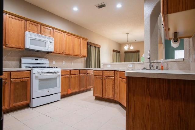 30615 S Sulphur Creek Dr, Magnolia, TX 77355 - kitchen featuring decorative backsplash, an inviting chandelier, white appliances, and visible vents