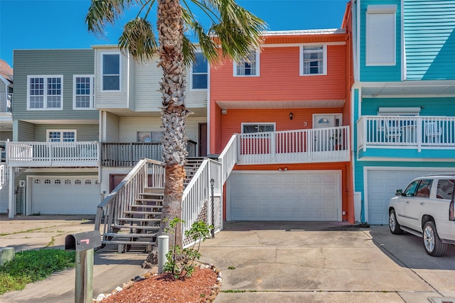 multi unit property featuring stairs, driveway, and a garage