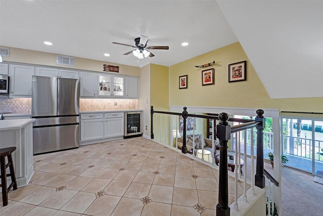 kitchen featuring light countertops, wine cooler, a ceiling fan, appliances with stainless steel finishes, and visible vents
