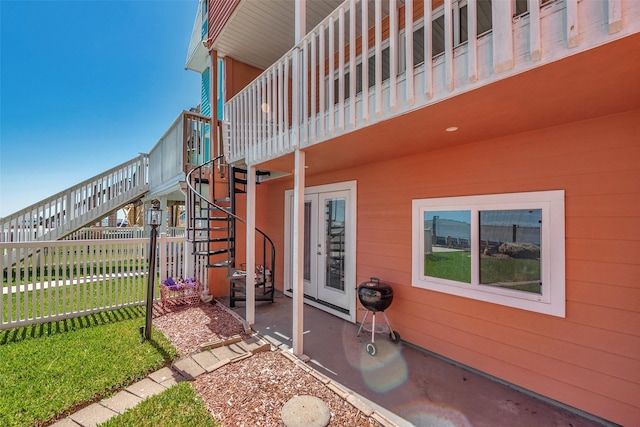 view of side of property with a patio area, stairs, and fence