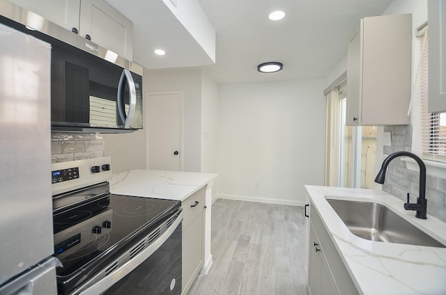 10501 S Dr Unit 300, Houston, TX 77099 - kitchen with tasteful backsplash, light wood finished floors, baseboards, appliances with stainless steel finishes, and a sink