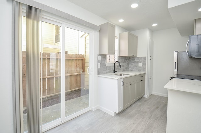 10501 S Dr Unit 300, Houston, TX 77099 - kitchen featuring tasteful backsplash, light wood finished floors, baseboards, appliances with stainless steel finishes, and a sink