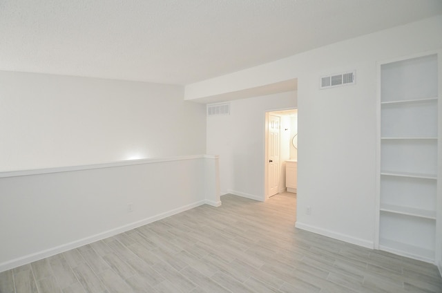 10501 S Dr Unit 300, Houston, TX 77099 - spare room featuring visible vents, light wood-type flooring, and baseboards