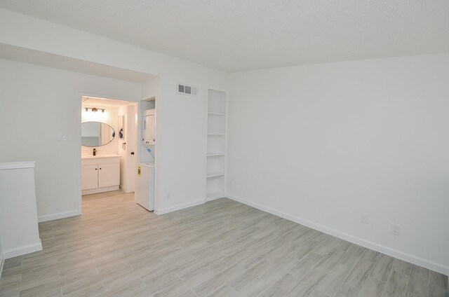 10501 S Dr Unit 300, Houston, TX 77099 - unfurnished room featuring baseboards, visible vents, light wood-style flooring, a sink, and a textured ceiling