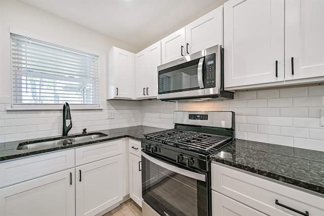 7119 Lumber Jack Dr, Houston, TX 77040 - kitchen with appliances with stainless steel finishes, a sink, white cabinetry, and dark stone countertops