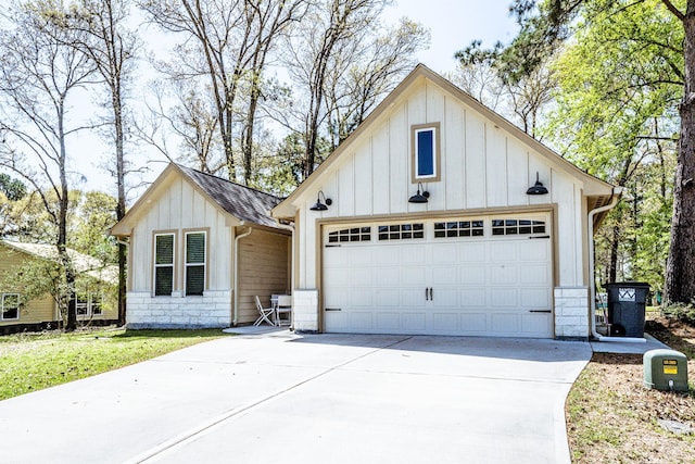 modern inspired farmhouse featuring an attached garage, an outdoor structure, board and batten siding, and concrete driveway