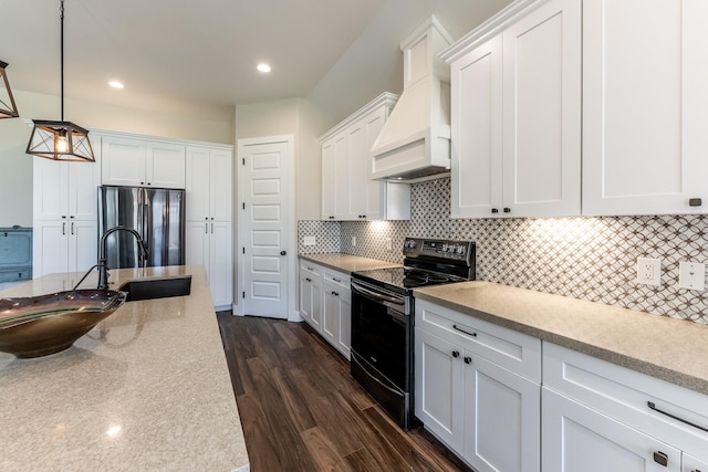 kitchen with a sink, appliances with stainless steel finishes, white cabinets, and decorative light fixtures