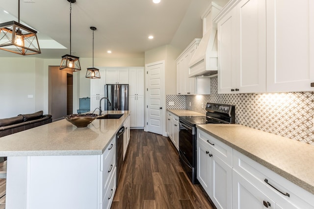 kitchen featuring black electric range, a sink, premium range hood, freestanding refrigerator, and dishwashing machine