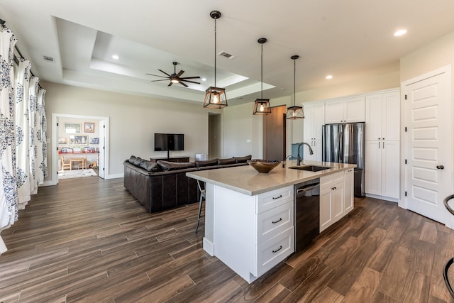 kitchen featuring white cabinets, a sink, a raised ceiling, dark wood-type flooring, and dishwashing machine