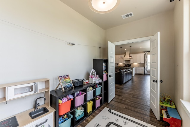 interior space with a sink, dark wood-type flooring, and visible vents