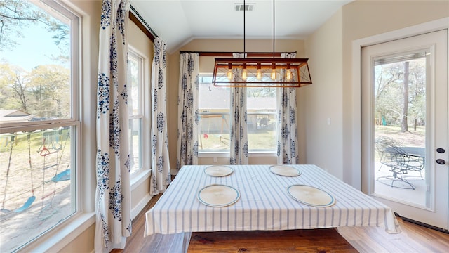 dining area featuring visible vents, wood finished floors, and lofted ceiling