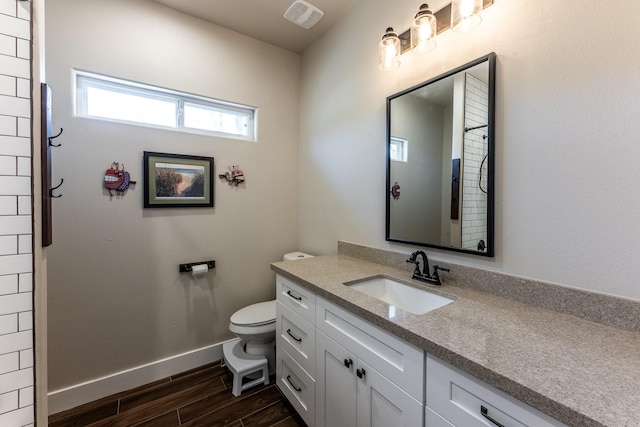 full bathroom featuring vanity, toilet, baseboards, wood finished floors, and visible vents