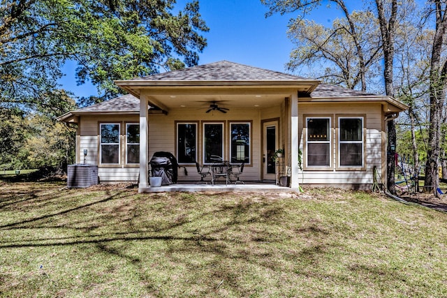 back of property featuring roof with shingles, cooling unit, a patio area, a lawn, and a ceiling fan