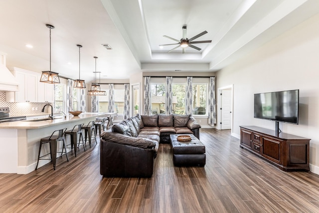 living area featuring baseboards, ceiling fan, dark wood-type flooring, and visible vents