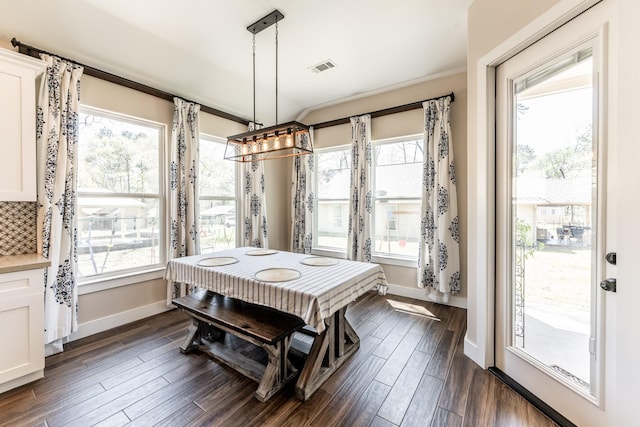 dining area featuring baseboards, visible vents, and dark wood-style floors