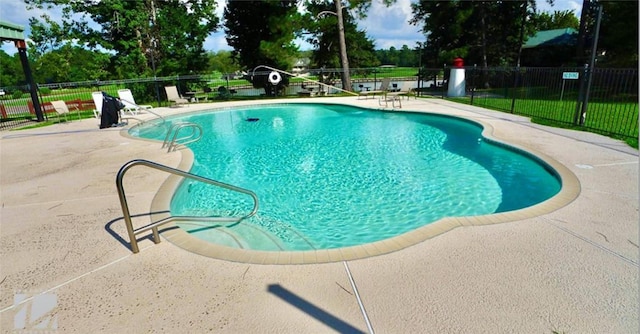 community pool with a patio and fence