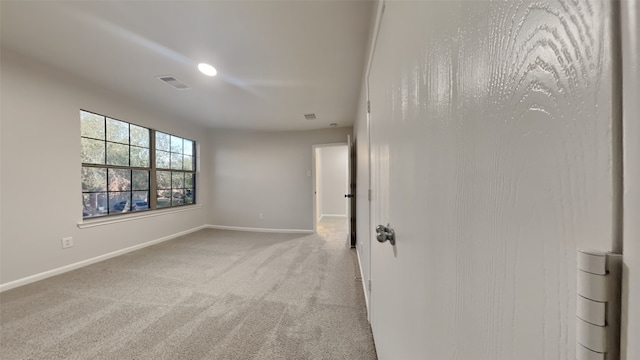 carpeted spare room with baseboards and visible vents