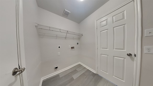 laundry room featuring hookup for a washing machine, laundry area, electric dryer hookup, light wood finished floors, and visible vents