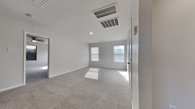 carpeted empty room with baseboards and a ceiling fan