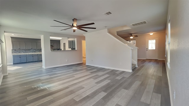 unfurnished living room featuring baseboards, visible vents, ceiling fan, and light wood-style flooring