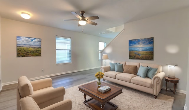 living area featuring wood finished floors, visible vents, a ceiling fan, and baseboards