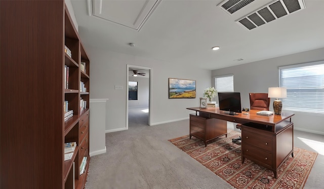 carpeted home office with baseboards, visible vents, attic access, and a ceiling fan
