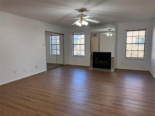 9850 Pagewood Ln Unit 1001, Houston, TX 77042 - unfurnished living room with ceiling fan, baseboards, dark wood-style floors, and a fireplace with raised hearth