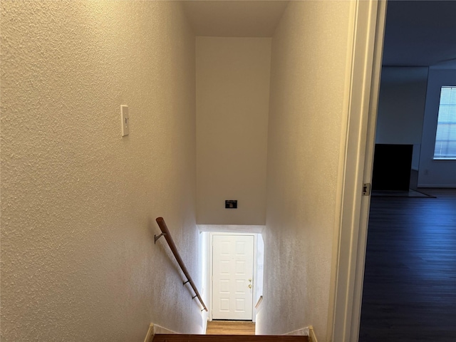 9850 Pagewood Ln Unit 1001, Houston, TX 77042 - staircase featuring a textured wall and wood finished floors