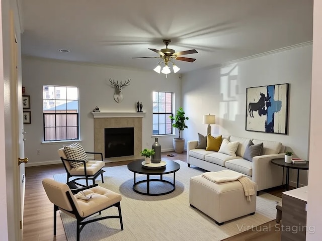 9850 Pagewood Ln Unit 1001, Houston, TX 77042 - living room featuring ceiling fan, wood finished floors, a tile fireplace, baseboards, and crown molding