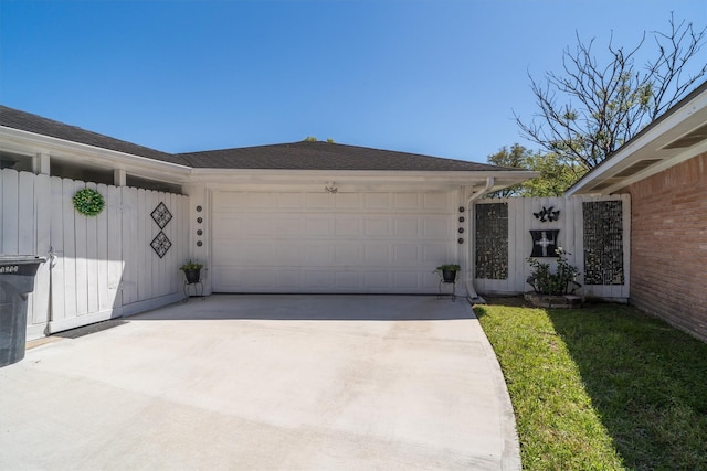 exterior space with concrete driveway, a garage, a shingled roof, and board and batten siding