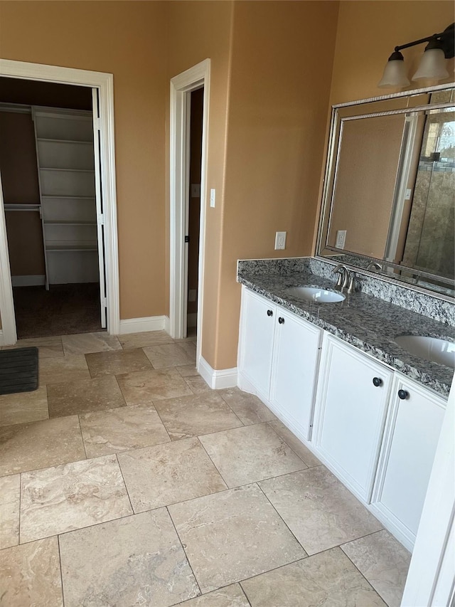 205 Rue Orleans St, Baytown, TX 77520 - full bath with double vanity, a sink, a shower with shower door, and baseboards