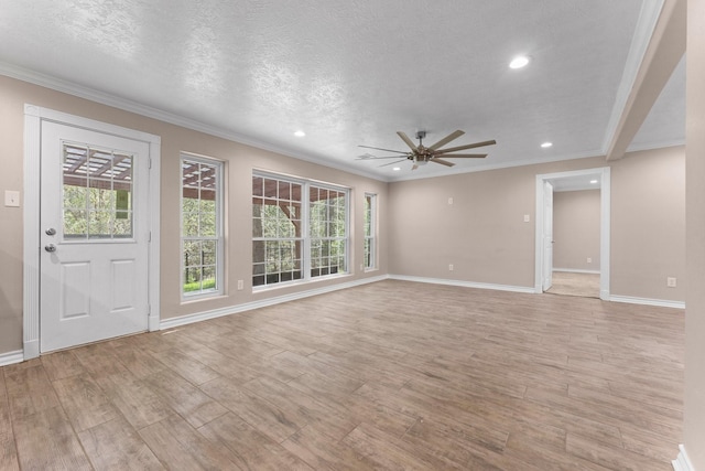 unfurnished living room with a textured ceiling, baseboards, ceiling fan, ornamental molding, and light wood-style floors