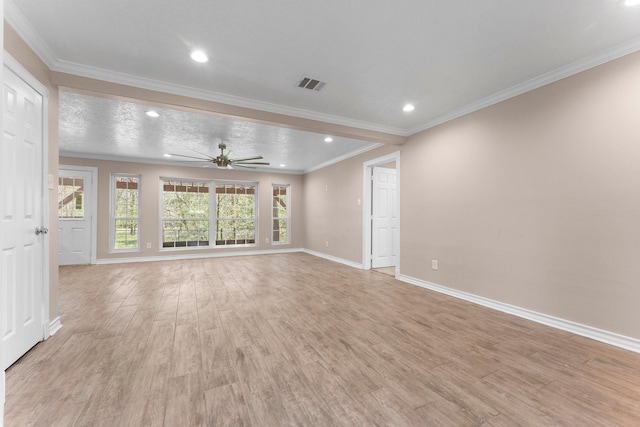 unfurnished living room featuring crown molding, light wood finished floors, baseboards, visible vents, and ceiling fan