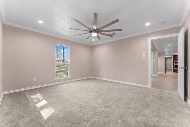 empty room with crown molding, recessed lighting, visible vents, light carpet, and ceiling fan
