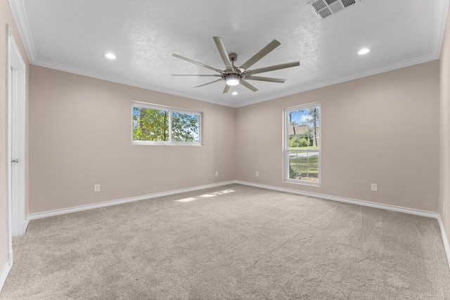 spare room featuring a ceiling fan, carpet floors, a healthy amount of sunlight, and visible vents