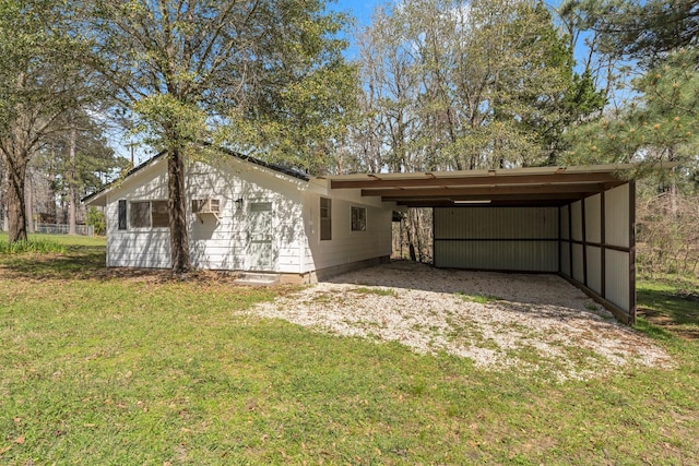 back of house with a lawn and an attached carport