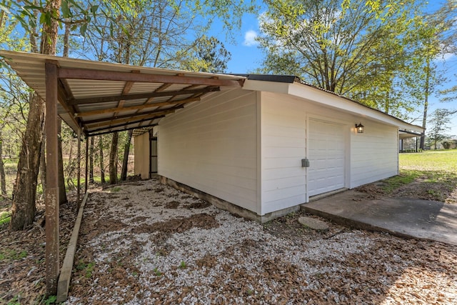 view of outdoor structure featuring driveway and a carport