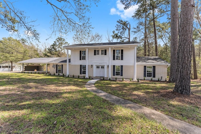 greek revival inspired property featuring brick siding and a front yard