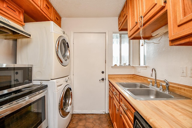 7885 Cook Rd, Houston, TX 77072 - laundry area with stacked washer / drying machine, dark tile patterned floors, a textured ceiling, a sink, and laundry area