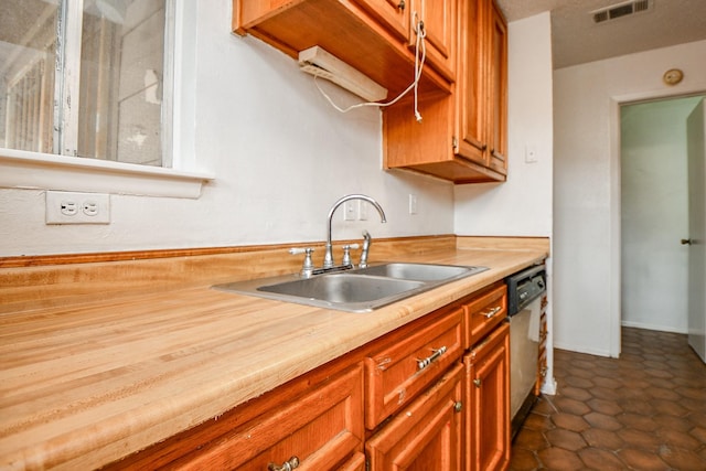7885 Cook Rd, Houston, TX 77072 - kitchen with visible vents, brown cabinetry, a sink, and dishwasher
