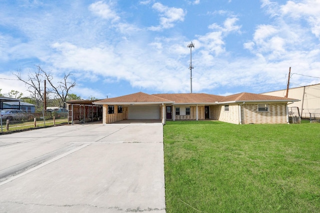 ranch-style house featuring concrete driveway, an attached garage, a front yard, brick siding, and an attached carport