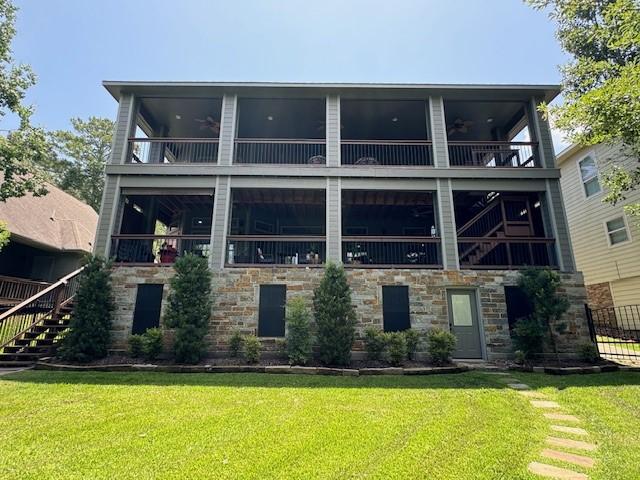 270 Lake Grove Dr, Coldspring, TX 77331 - rear view of property featuring a balcony, stone siding, ceiling fan, and a yard