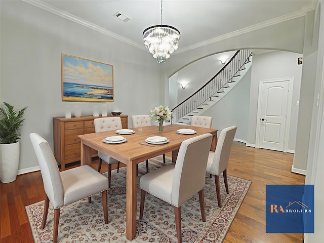 270 Lake Grove Dr, Coldspring, TX 77331 - dining area with stairs, a chandelier, arched walkways, crown molding, and light wood-style floors