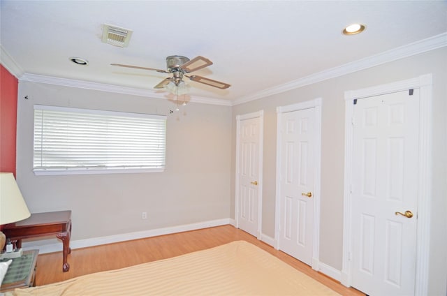 2719 Sweetgum St, Pasadena, TX 77502 - unfurnished bedroom with multiple closets, crown molding, wood finished floors, baseboards, and recessed lighting
