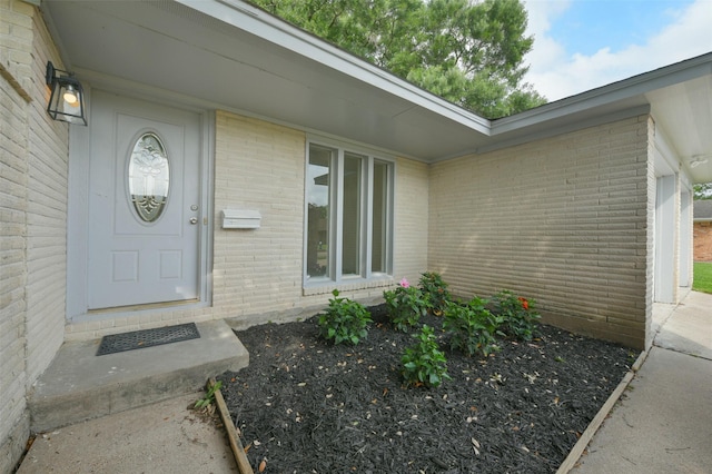 view of exterior entry with brick siding