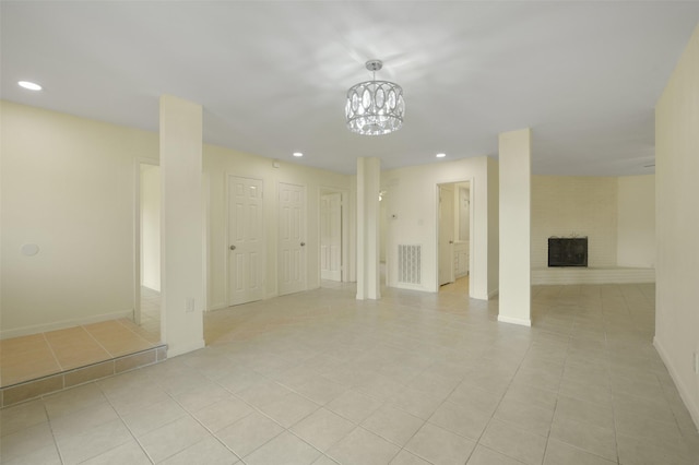 basement featuring visible vents, baseboards, recessed lighting, a brick fireplace, and light tile patterned floors