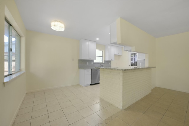 kitchen with light stone counters, decorative backsplash, light tile patterned flooring, dishwasher, and white cabinetry