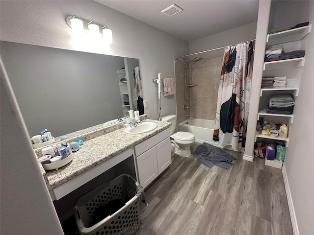 2395 Monroe St, Beaumont, TX 77703 - full bath featuring visible vents, toilet, wood finished floors, vanity, and shower / tub combo with curtain