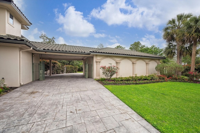 1204 Cowards Creek Dr, Friendswood, TX 77546 - view of property exterior with driveway, a tile roof, stucco siding, a carport, and a lawn